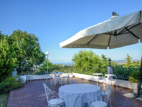 eine Terrasse mit einem Tisch und einem Sonnenschirm in der Unterkunft Belvilla by OYO Ca Bianca in Montefiore Conca