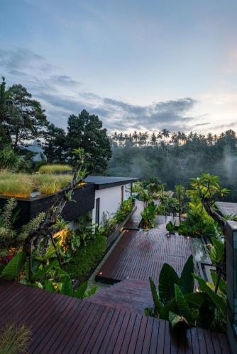 a house with a wooden deck with plants on it at Zenubud in Ubud