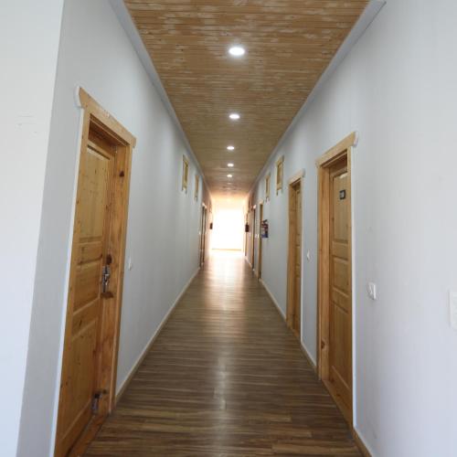 an empty hallway with wooden doors and a hallway with a hallwayngth at Le ROI Floating Huts & Eco Rooms Tehri in Tehri-Garhwāl