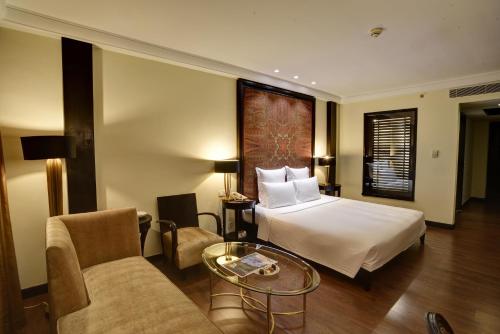 a hotel room with a bed and a table at Pearl Continental Hotel, Muzaffarabad in Muzaffarabad