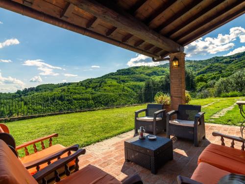 a patio with furniture and a view of the mountains at Belvilla by OYO Villa Luciana in Piteccio