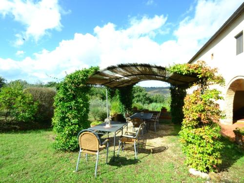 - une table et des chaises sous un parasol dans la cour dans l'établissement Cozy Home in San Casciano in Val di Pesa with BBQ, à San Casciano in Val di Pesa