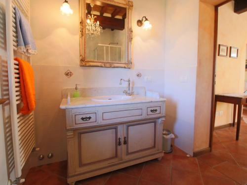 a bathroom with a sink and a mirror at Farmhouse with private terrace, garden and pool, overlooking the town of Cortona in Cortona