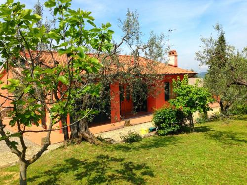 a red house with a yard and trees at Belvilla by OYO Il Camino in Montespertoli