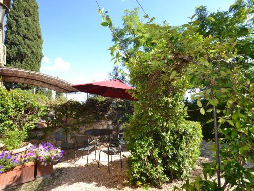 タヴァルネッレ・ヴァル・ディ・ペーザにあるLush Holiday Home in Tavarnelle Val di Pesa with Shared Poolの庭園(テーブル、椅子、パラソル付)