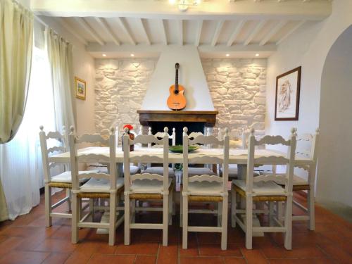 PiegaioにあるBelvilla by OYO Villa Magnoliaのダイニングルーム(テーブル、椅子、ギター付)