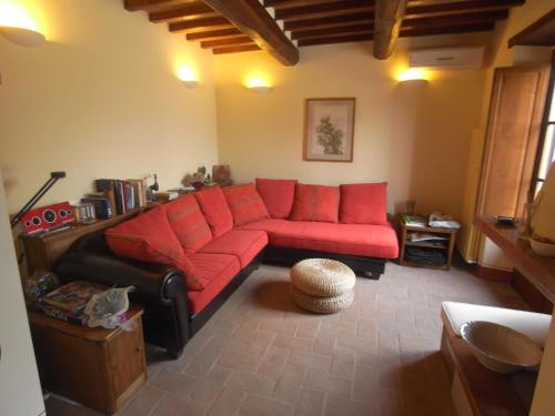 salon z czerwoną kanapą w pokoju w obiekcie Belvilla by OYO Casina la Graziosa w mieście Cortona