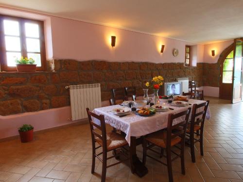 a dining room with a table with chairs and flowers on it at Belvilla by Oyo Sorano in Sorano