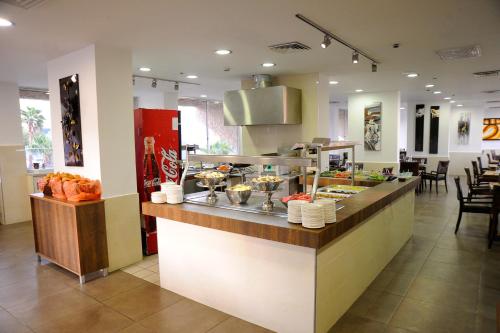 a restaurant with a counter with food on it at Aquamarine Hotel in Eilat