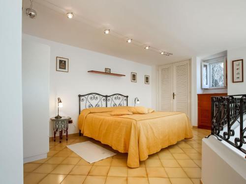 een slaapkamer met een bed met een gele deken erop bij Belvilla by OYO Arienzo in Positano