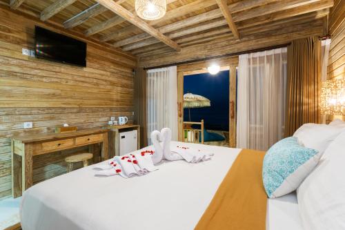 a bedroom with a white bed and a television at The Dewi Premier Nusa Penida in Nusa Penida