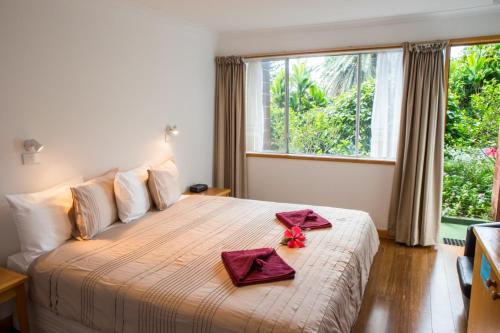 ein Schlafzimmer mit einem großen Bett mit roten Servietten darauf in der Unterkunft Seaview Norfolk Island in Burnt Pine