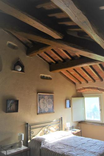 a bedroom with a bed and wooden ceilings at La valle B&B in Cavriglia