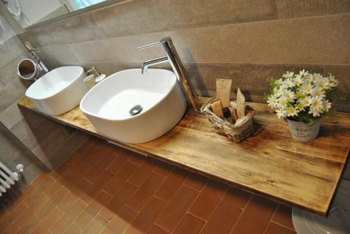 a bathroom with two sinks and flowers on a wooden counter at La valle B&B in Cavriglia