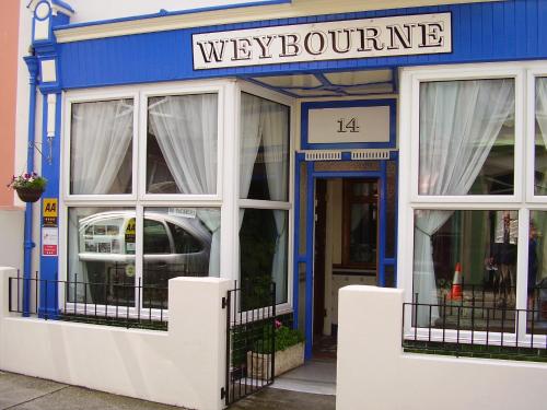 a store front with a blue and white building at Weybourne Guest House in Tenby