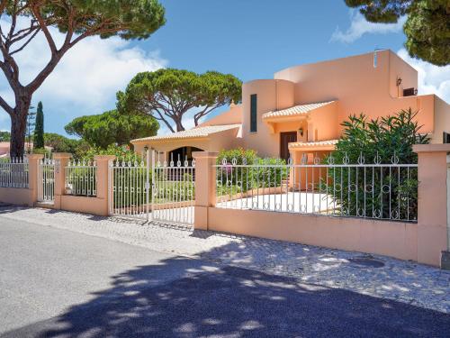 a house with an orange fence and trees at Wonderful villa in Vilamoura with barbecue and private swimming pool in Vilamoura