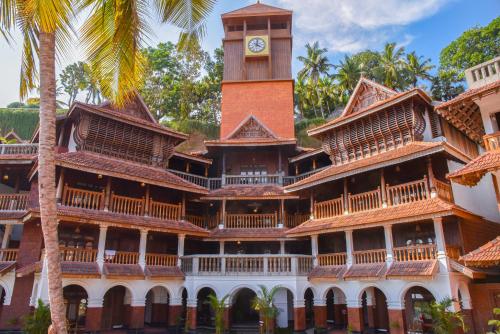 a large building with a clock tower at AyurSoma Ayurveda Royal Retreat in Kovalam