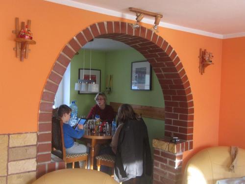 Eine Frau und ein Kind sitzen an einem Tisch in einem Restaurant. in der Unterkunft Spacious Holiday Home in Stara Kamienica with Pond in Stara Kamienica