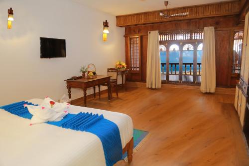 a bedroom with a bed and a desk and a television at AyurSoma Ayurveda Royal Retreat in Kovalam