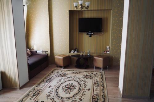 a living room with a couch and a tv on the wall at Evropeyskiy in Kyiv
