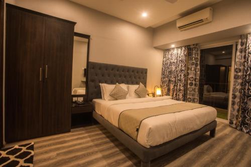パナジにあるEncore Suites Goaのベッドルーム1室(大型ベッド1台付)