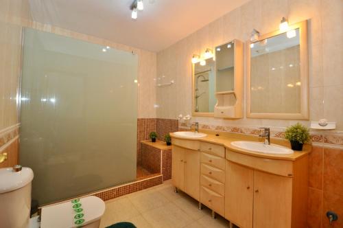 a bathroom with two sinks and a shower and a toilet at Villa Talia in Lloret de Mar