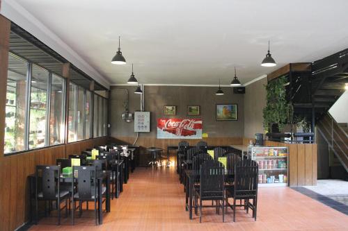 een eetkamer met zwarte stoelen en tafels bij Bamboe Inn 2 Homestay in Tanjungkarang