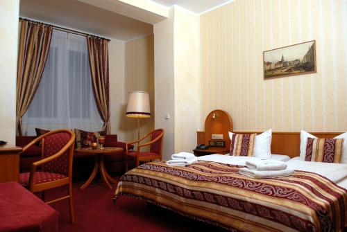 ツィッタウにあるHotel Schwarzer Bärのベッドとテーブルが備わるホテルルームです。