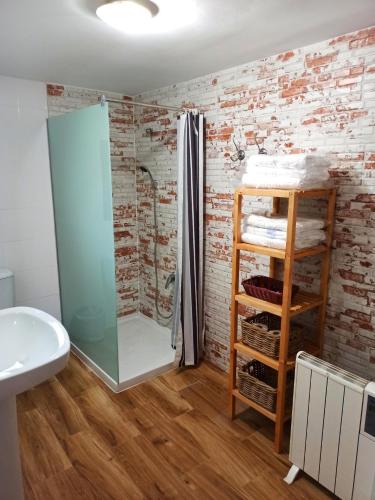 a bathroom with a brick wall and a shower at Cortijo Ramon Petra in Nerpio