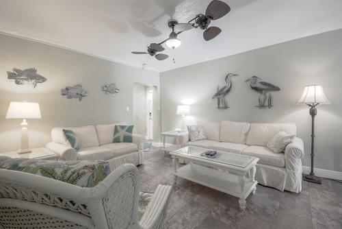 ein Wohnzimmer mit zwei Sofas und Vögeln an der Wand in der Unterkunft Clearwater Beach Suites 105 condo in Clearwater Beach