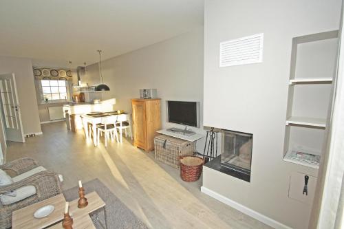 Una sala de estar con un sofá y una chimenea. en Seepark Seepark 3f, en Heiligenhafen