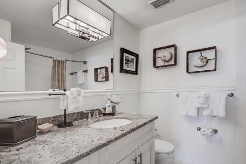 a white bathroom with a sink and a mirror at Clearwater Beach Suites 201 condo in Clearwater Beach