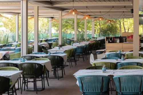 una fila di tavoli e sedie in un ristorante di Mediterraneo Camping Village a Cavallino-Treporti