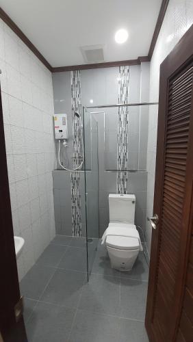 a bathroom with a toilet and a glass shower at Sabua The Terrace Homestay in Uthai Thani