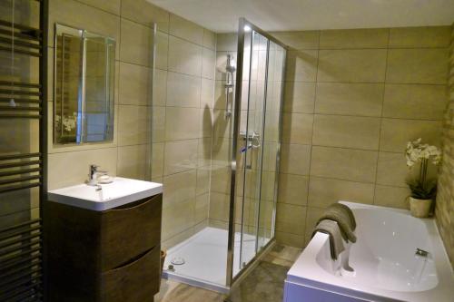 a bathroom with a shower and a sink and a tub at Rosedale Cottage in Rosedale Abbey