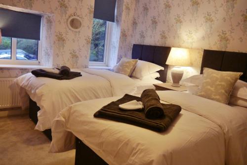 a bedroom with three beds with towels on them at Rosedale Cottage in Rosedale Abbey