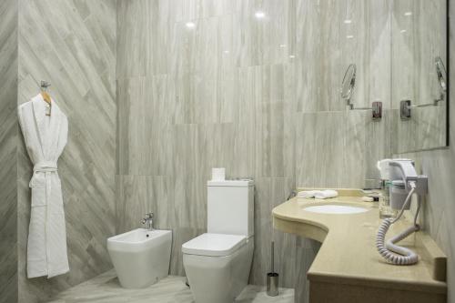a bathroom with a toilet and a sink at Marlin in Odesa