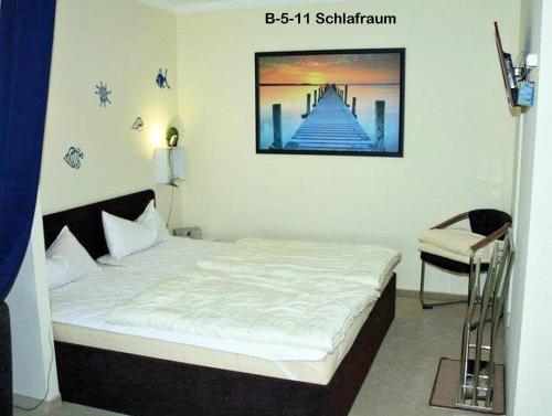 ein Schlafzimmer mit einem Bett mit einem Bild an der Wand in der Unterkunft Ferienpark B05-011 Ferienpark in Heiligenhafen