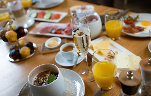 a wooden table with plates of food and glasses of champagne at Hotel Landhaus in Münster