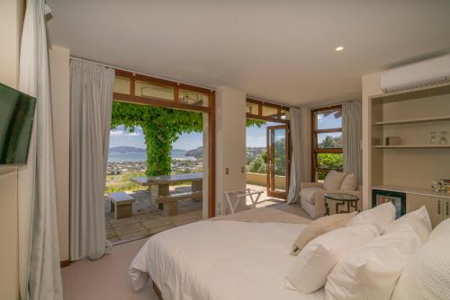 a bedroom with a large bed and a large window at Mercury Ridge in Cooks Beach