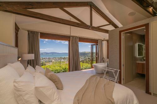 a bedroom with a bed and a view of a bathroom at Mercury Ridge in Cooks Beach