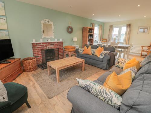 a living room with a couch and a fireplace at Sandy Cove in Chathill