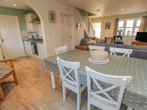 a kitchen and living room with a table and chairs at Sandy Cove in Chathill