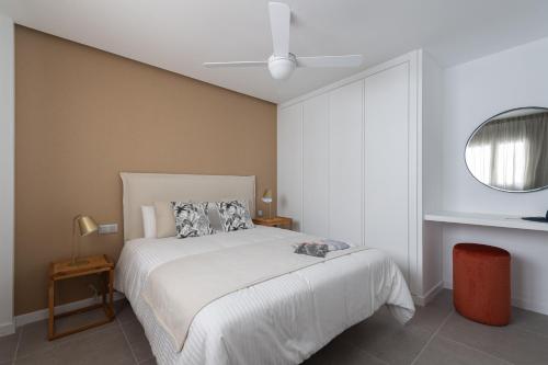 a bedroom with a large white bed and a mirror at Royal Flats in Las Palmas de Gran Canaria