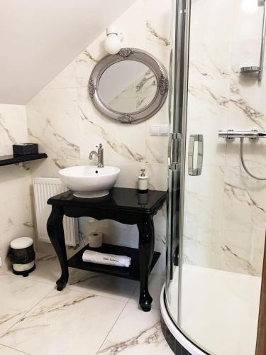 a bathroom with a sink and a shower at Dwór Karwacz in Przasnysz