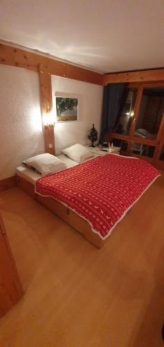 a bedroom with a large bed with a red blanket at Appartement - Bristol Hôtel in Villars-sur-Ollon