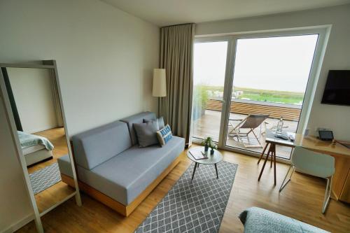 a living room filled with furniture and a window at Hotel Strandhus in Cuxhaven
