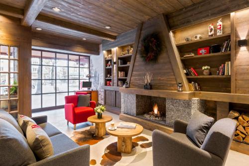 a living room with a fireplace and a red chair at Edelweiss Manotel in Geneva