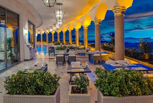 a restaurant with tables and chairs and a view of the ocean at Be Premium Bodrum in Torba