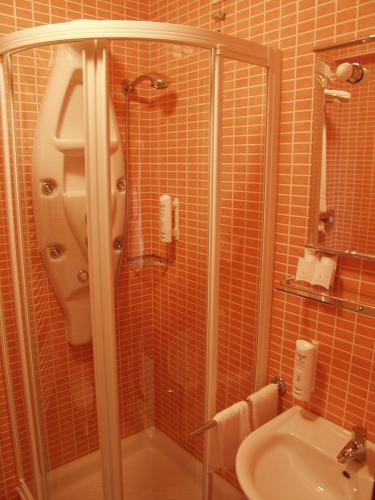 a bathroom with a shower and a sink at Hotel Park in Lovran